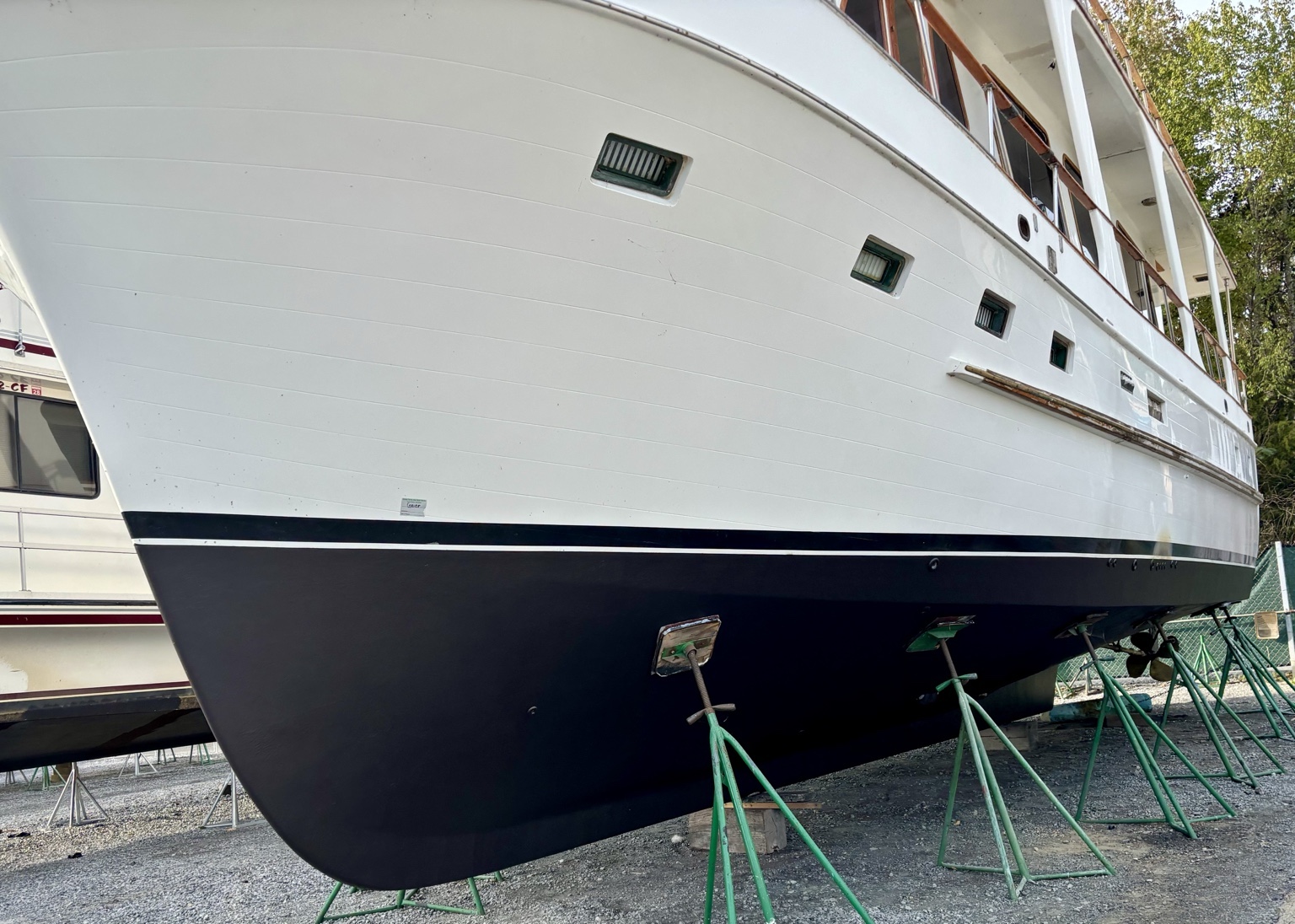 Starboard bow and hull of Hunky Dory supported on stands while hauled out