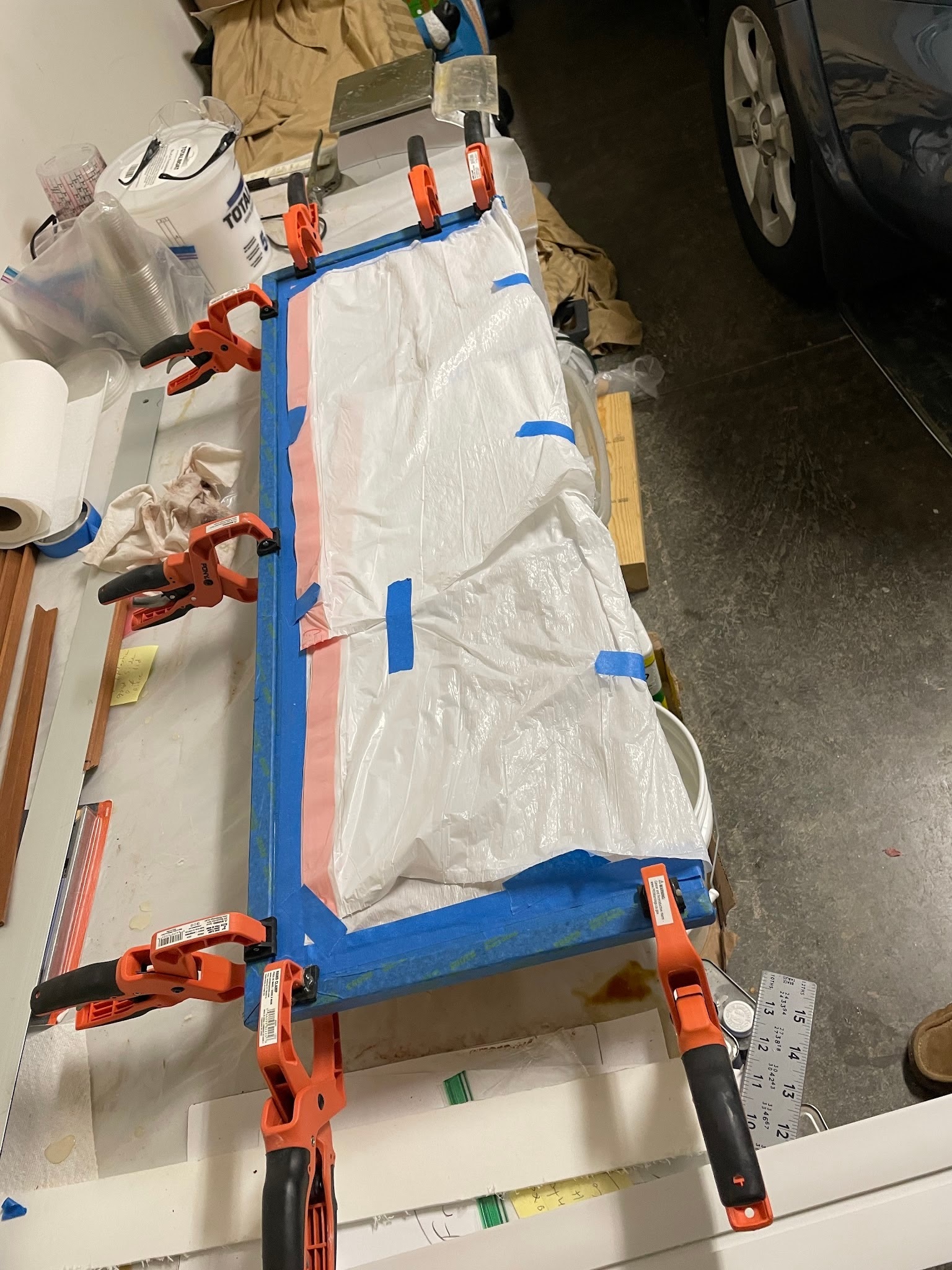 Clamps holding corner-round trim to the front panel while epoxy cures