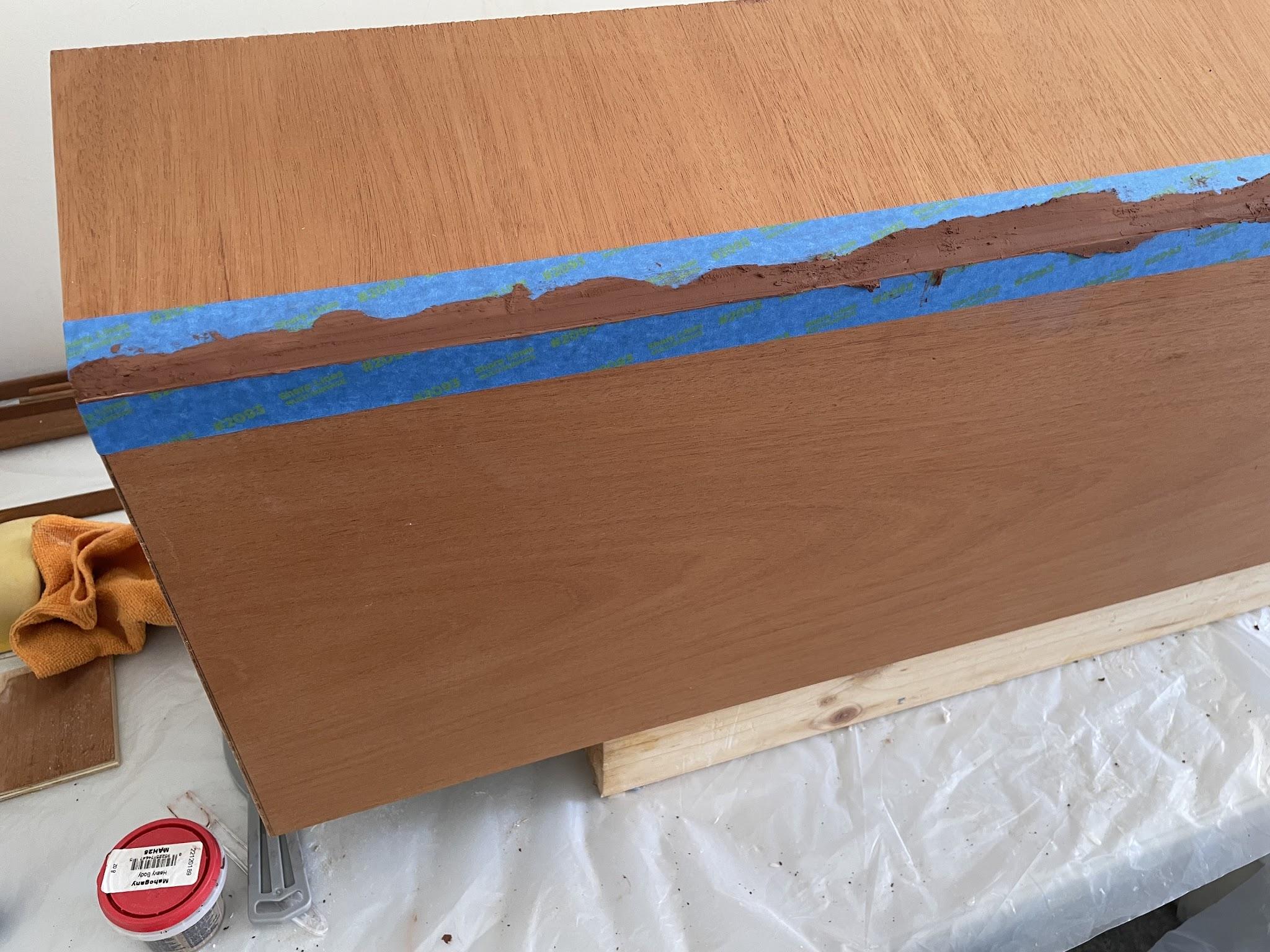 Mahogany-tinted filler applied to the cabinet back joint